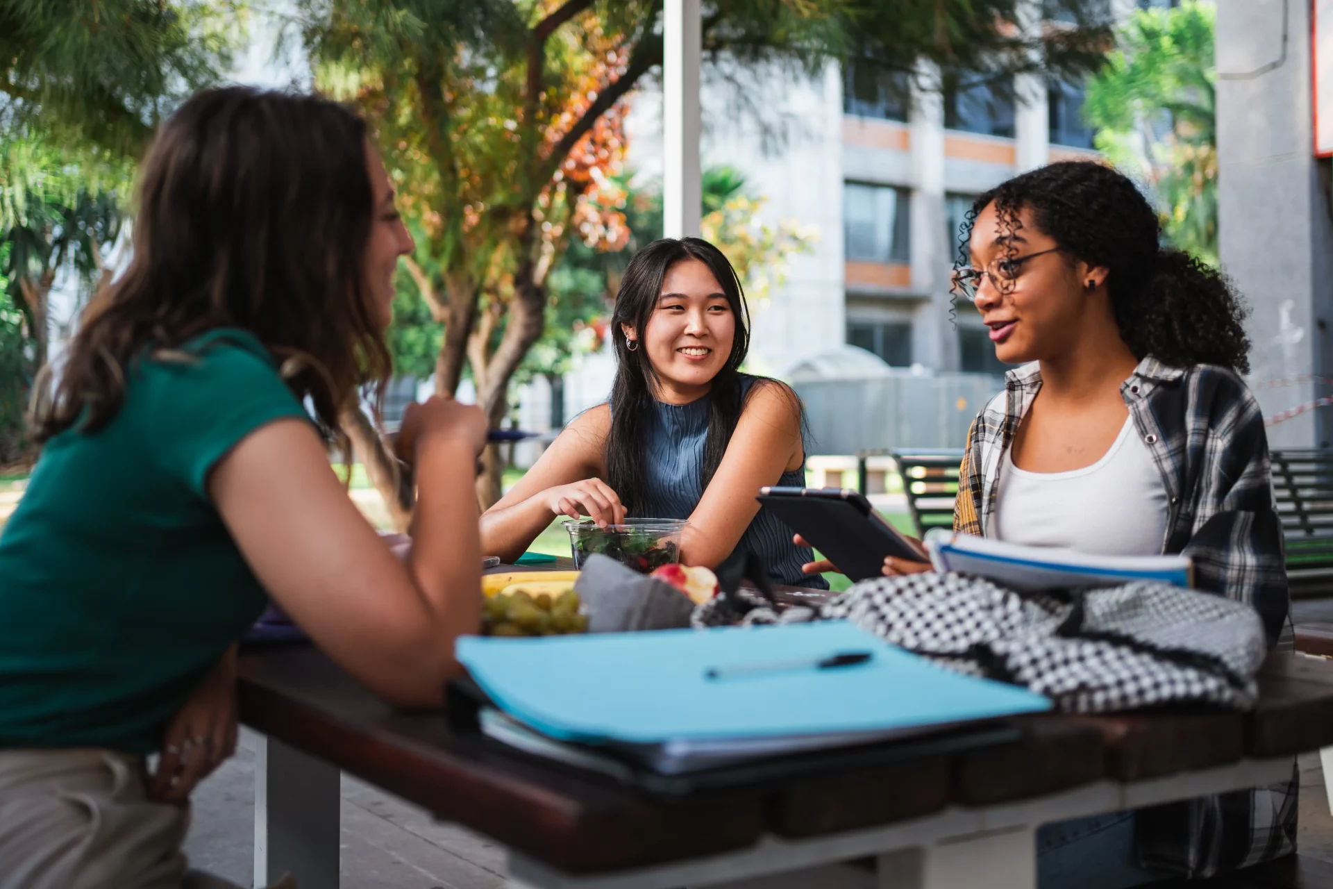Three students sat around a table talking