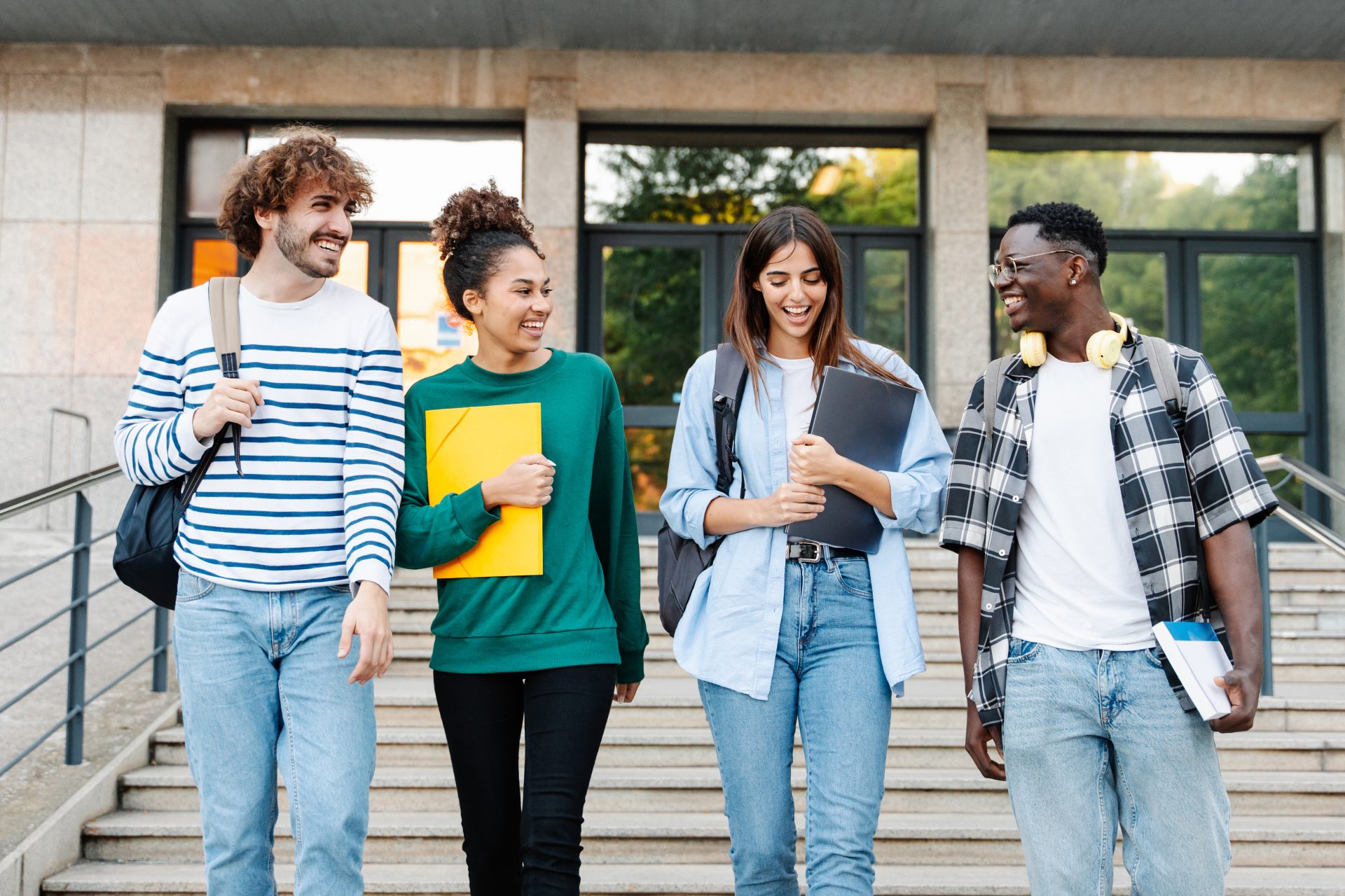 Group of 4 students walking down steps after class