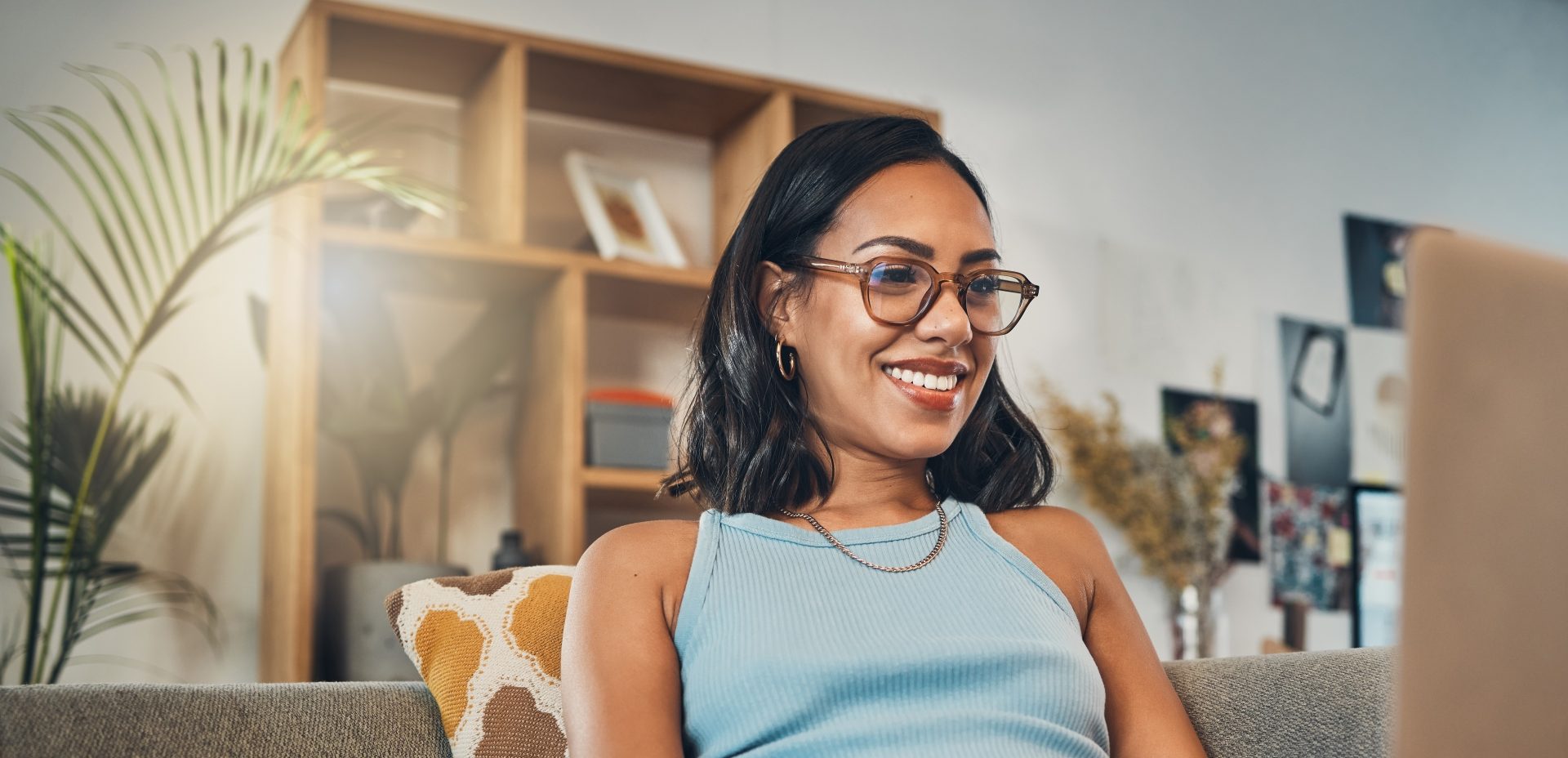 Female student sat on sofa working on laptop